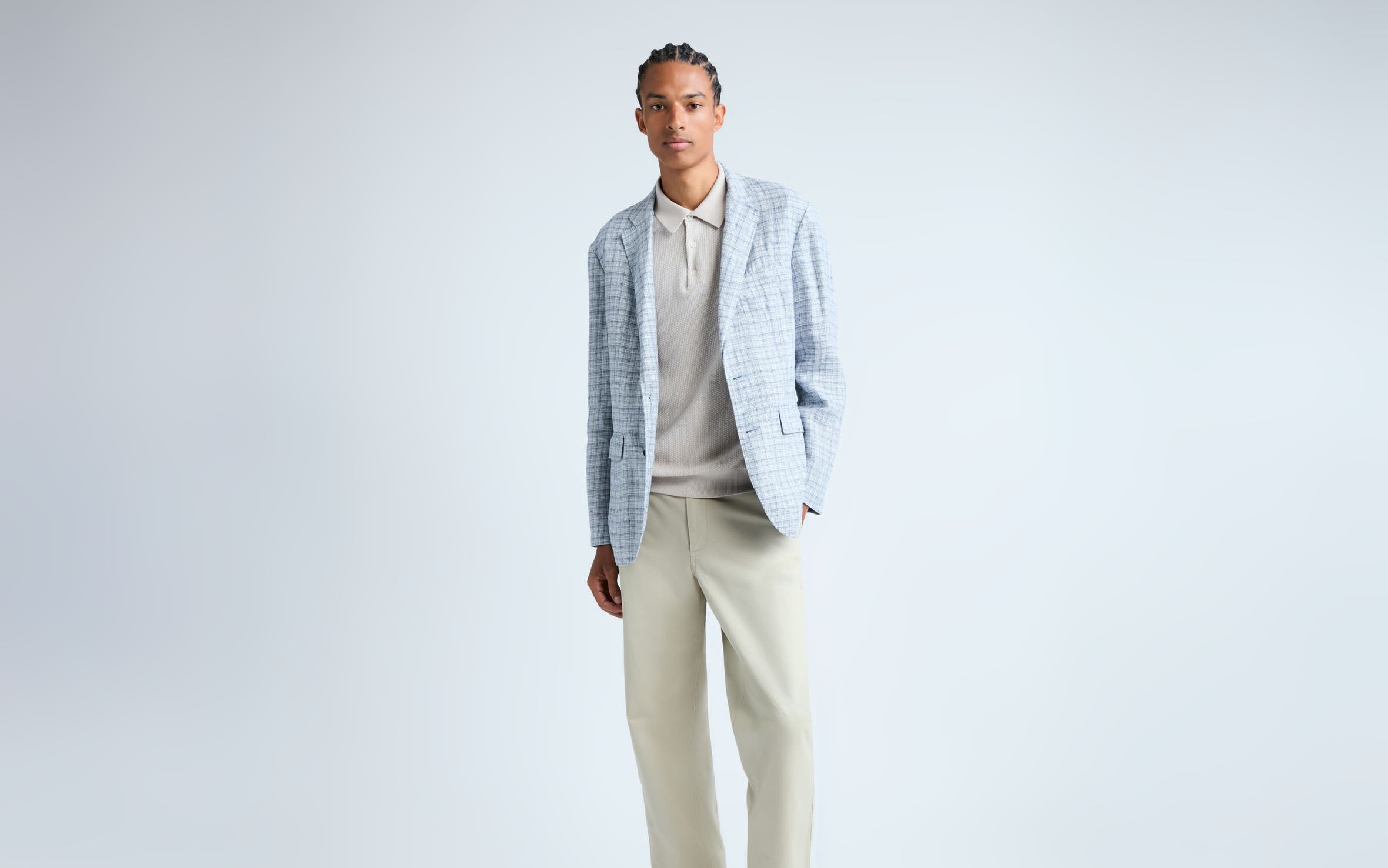 Man wearing a plaid blazer, knit polo, pants and loafers.