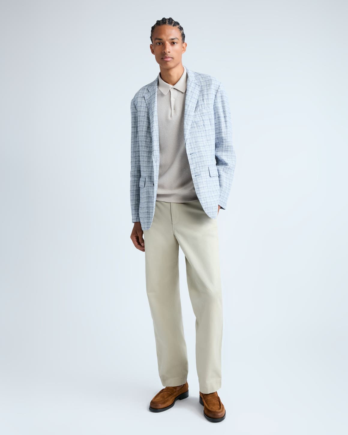 Man wearing a plaid blazer, knit polo, pants and loafers.