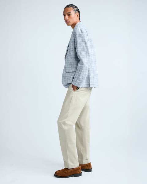 Man wearing a plaid blazer and tan pants.
