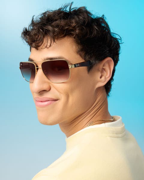 A man wearing sunglasses and a yellow sweatshirt.