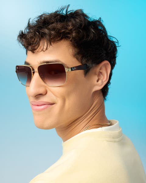 A man wearing sunglasses and a yellow sweatshirt.