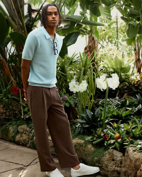 Man wearing brown tailored pants and team crochet polo.
