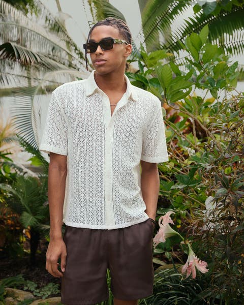 A man wearing a casual shirt and shorts.