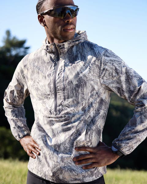 A man wearing a printed jacket and sunglasses.
