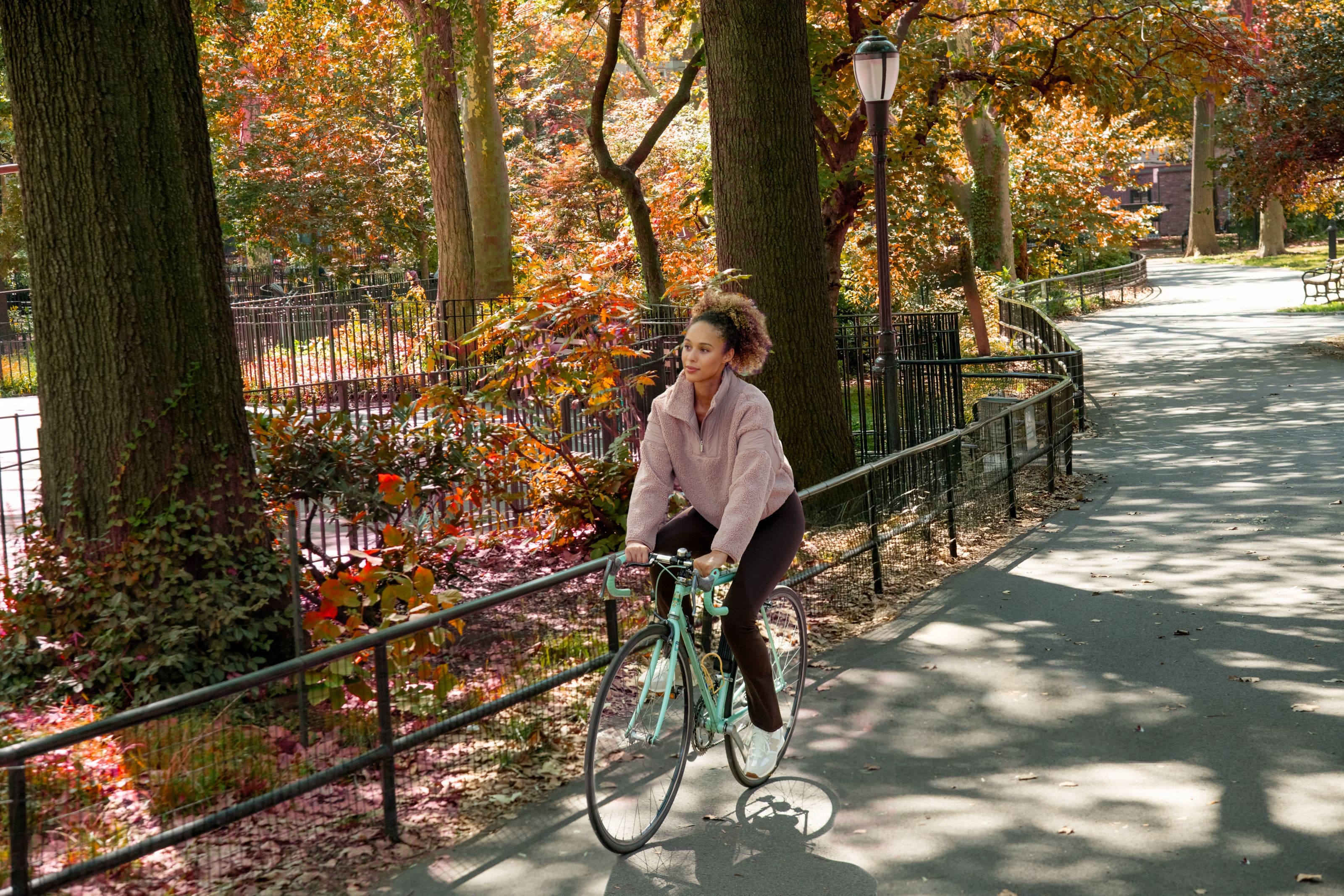 A woman wearing a faux shearling jacket, leggings and sneakers.