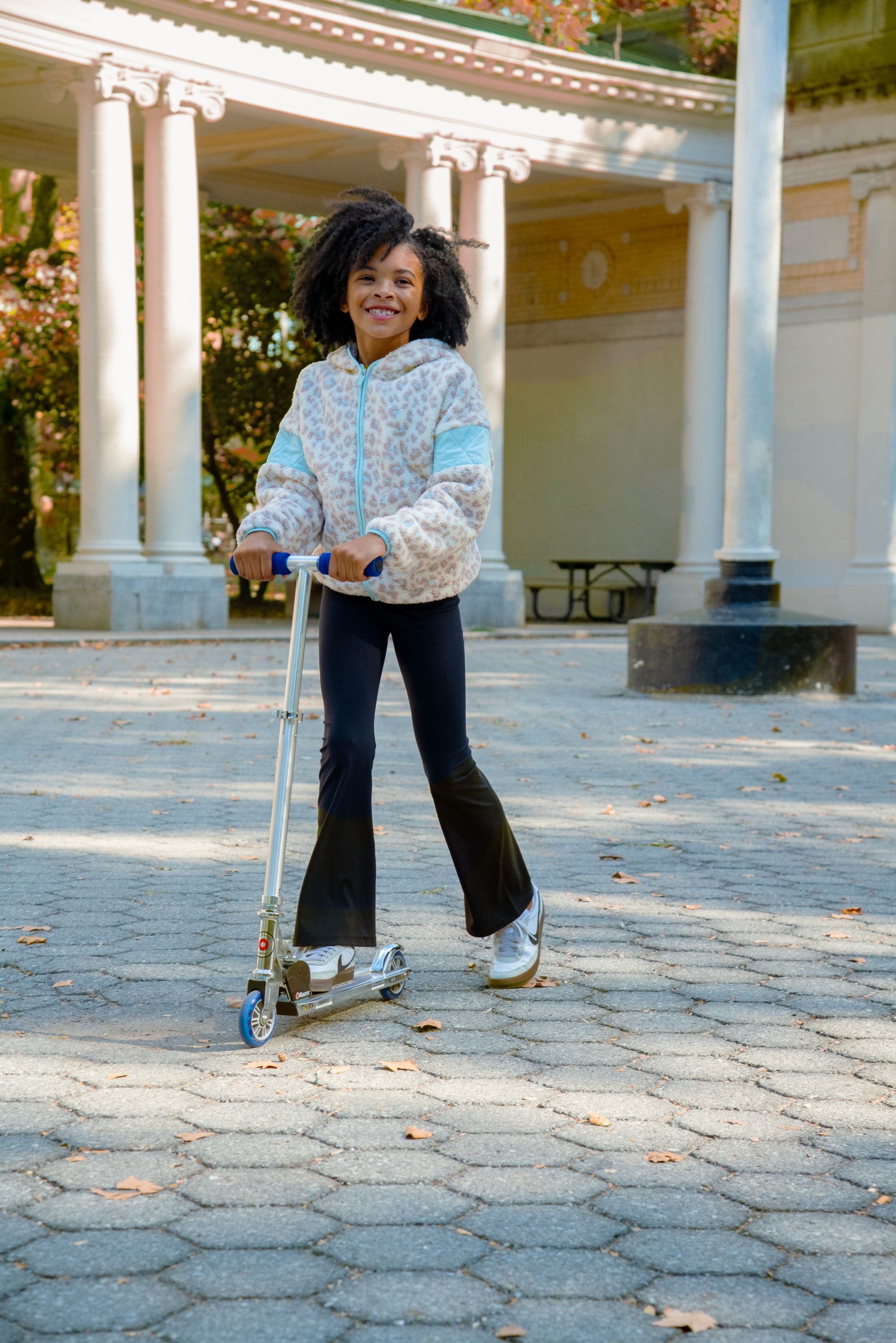 A girl wearing a leopard-print fleece and flared leggings.