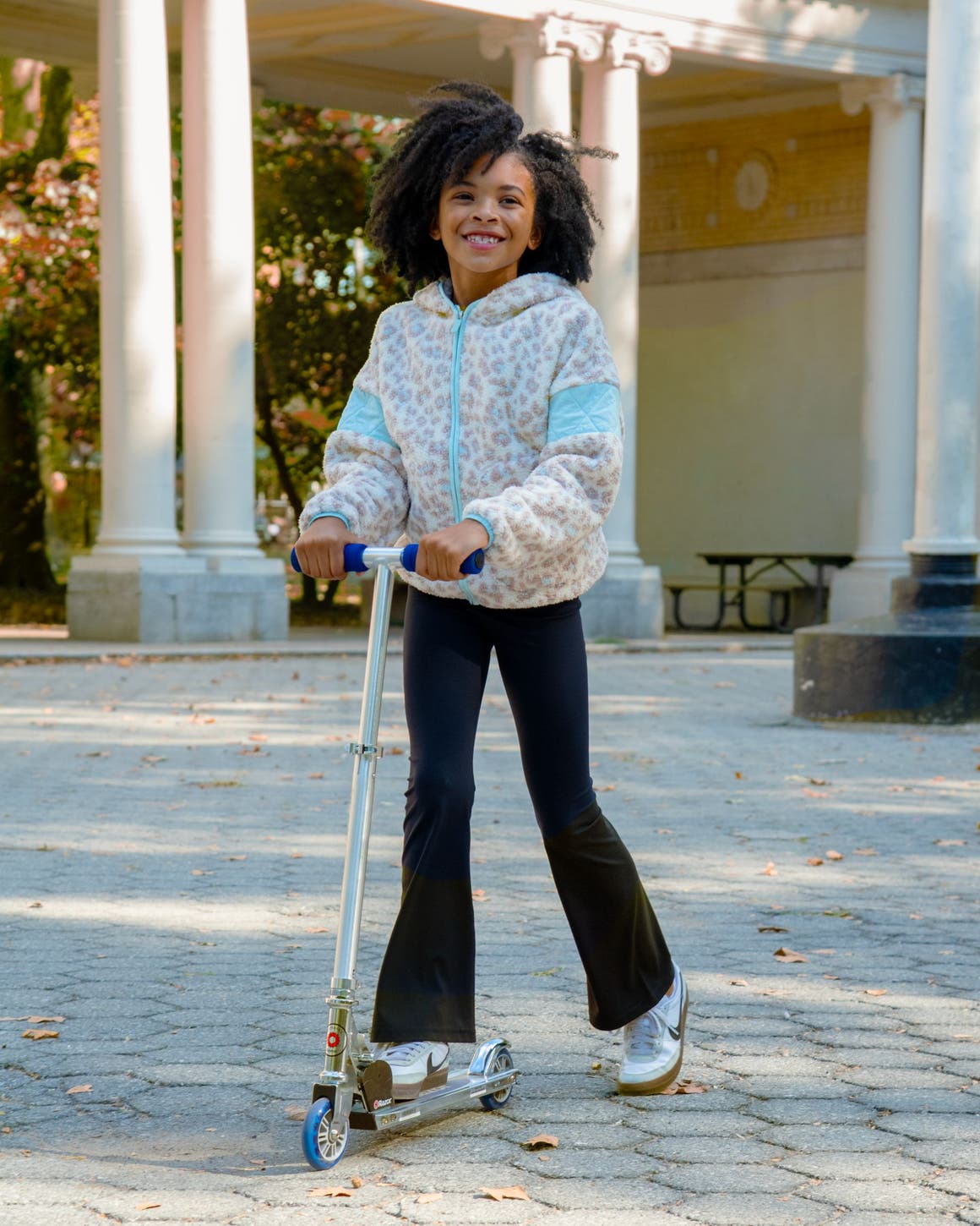 A girl wearing a leopard-print fleece and flared leggings.