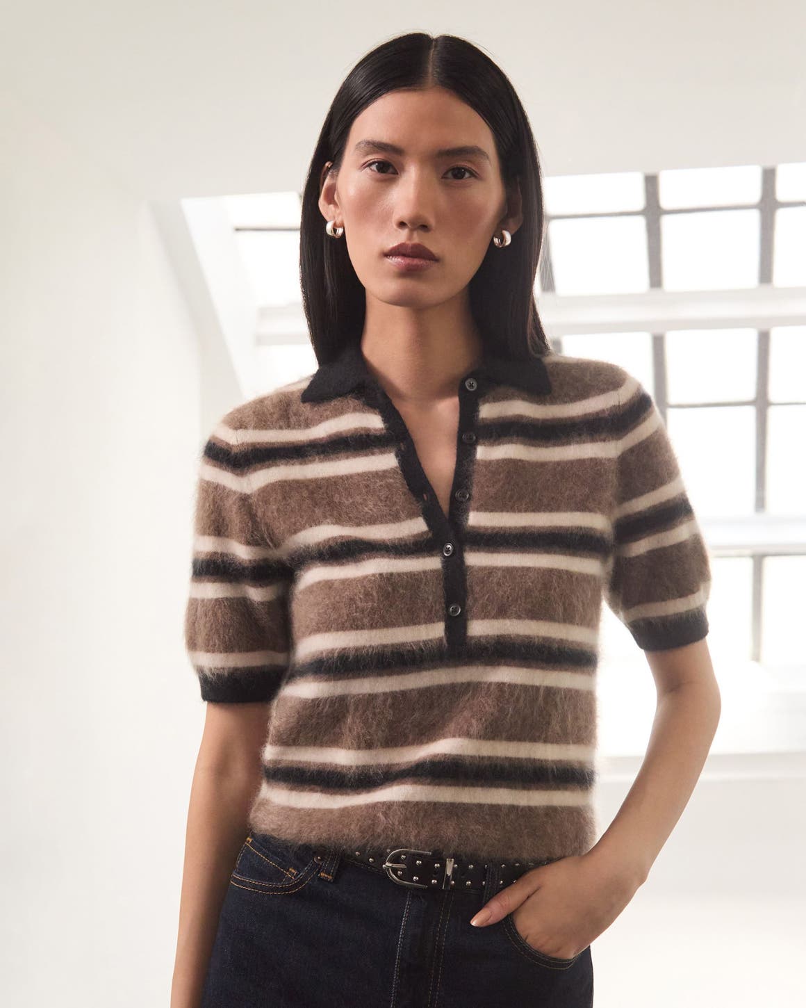 A woman wearing a striped top and jeans.