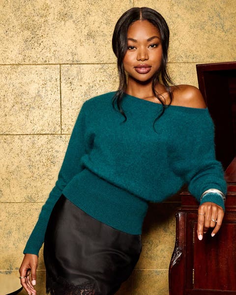 A woman in a teal off-shoulder sweater.