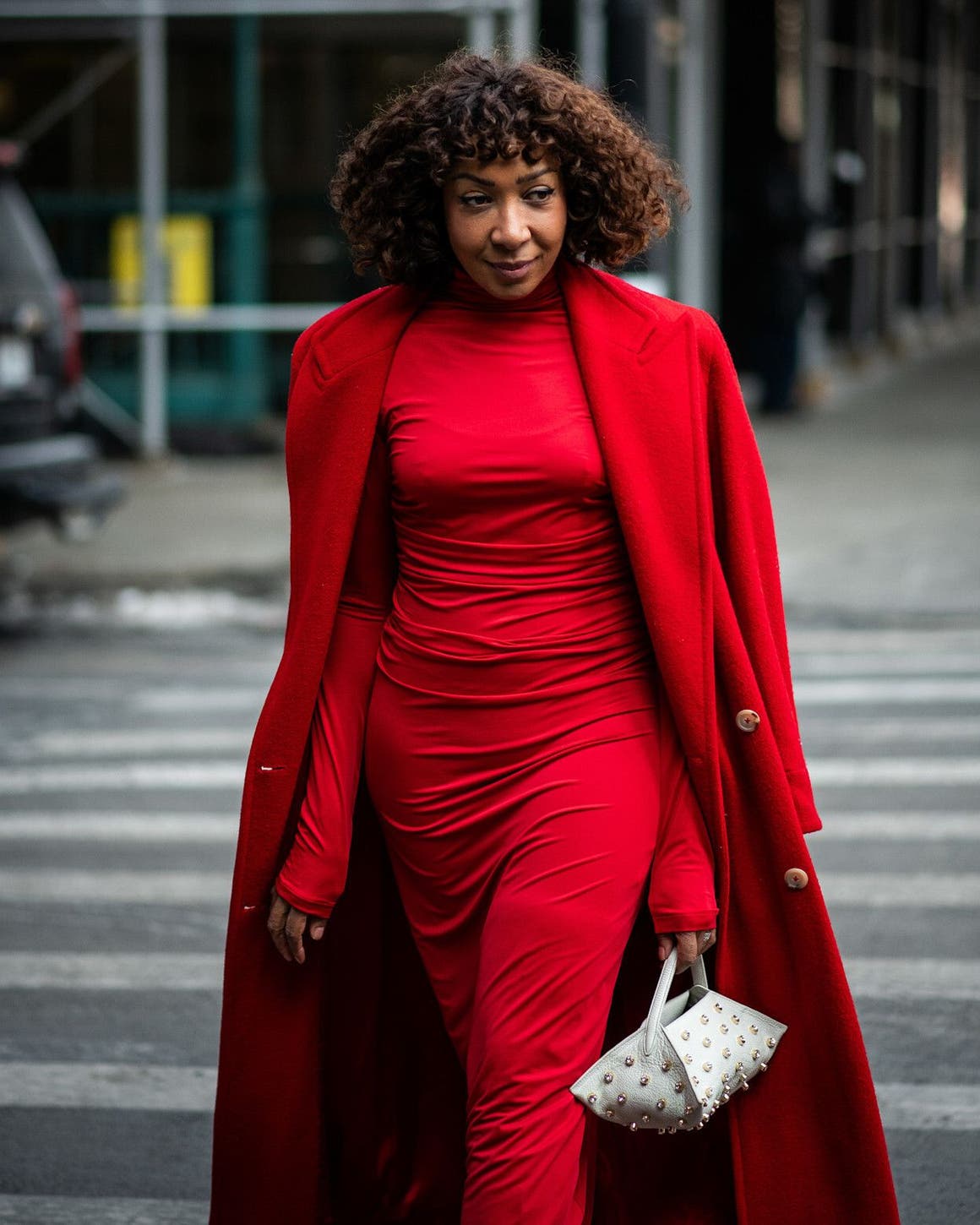 Woman in a red dress and coat at New York Fashion Week.