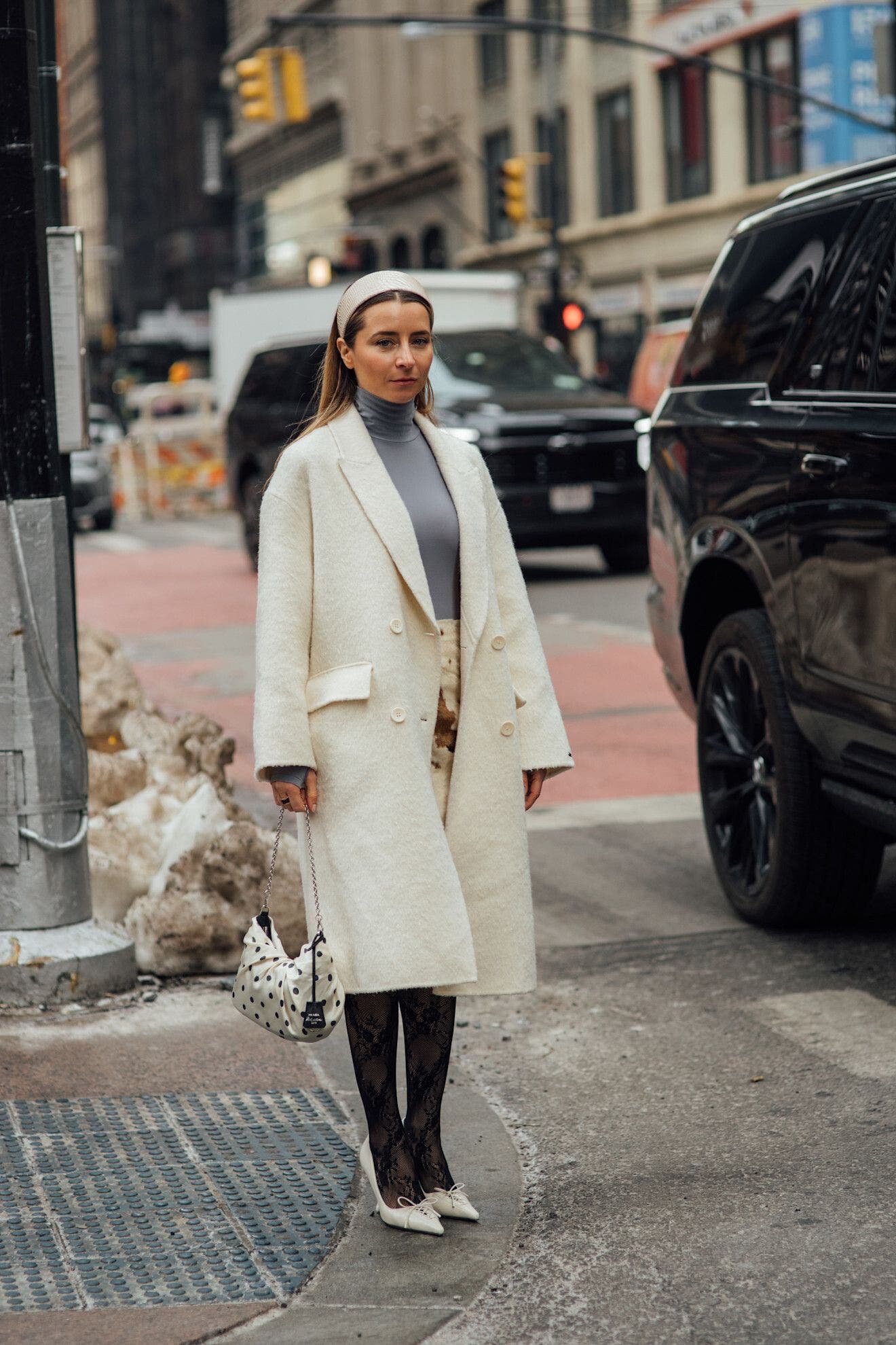 Woman in black lace stockings and cream heels at New York Fashion Week.