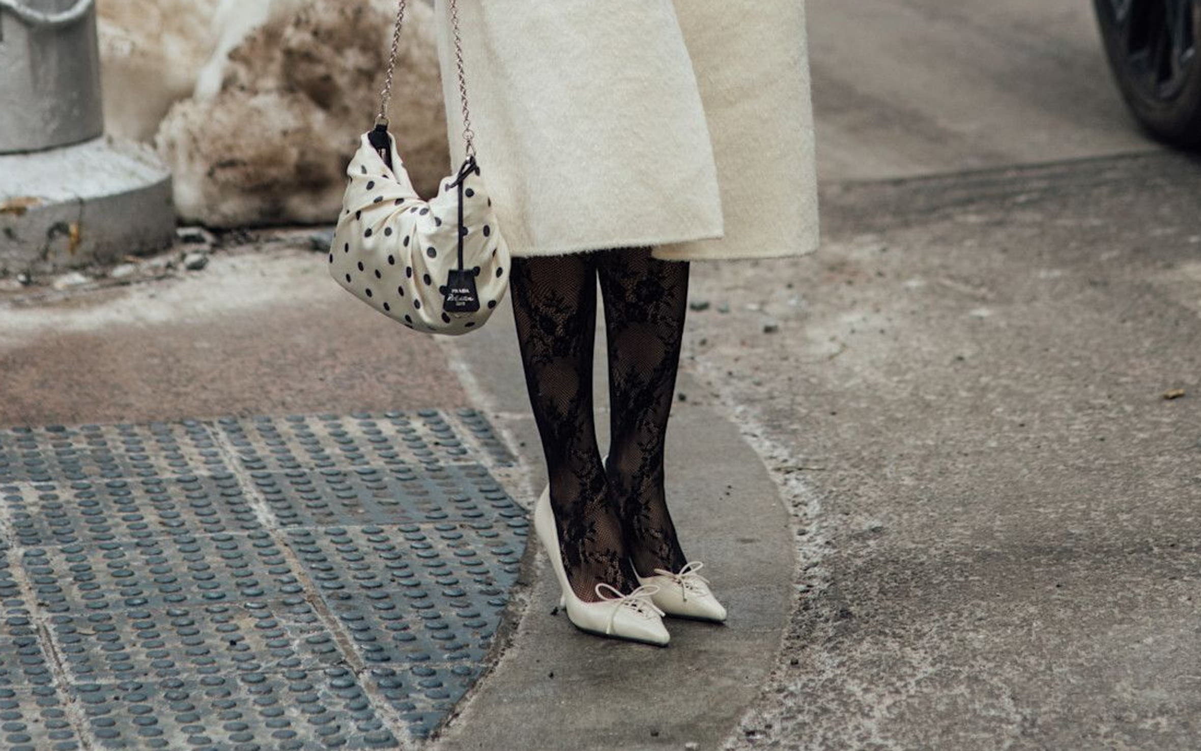 Woman in black lace stockings and cream heels at New York Fashion Week.