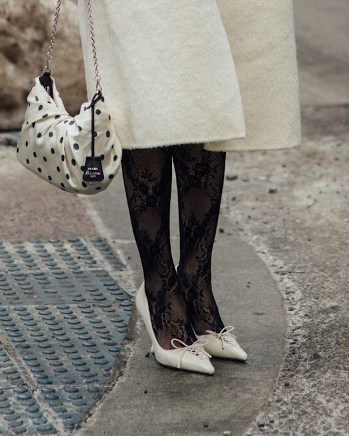 Woman in black lace stockings and cream heels at New York Fashion Week.