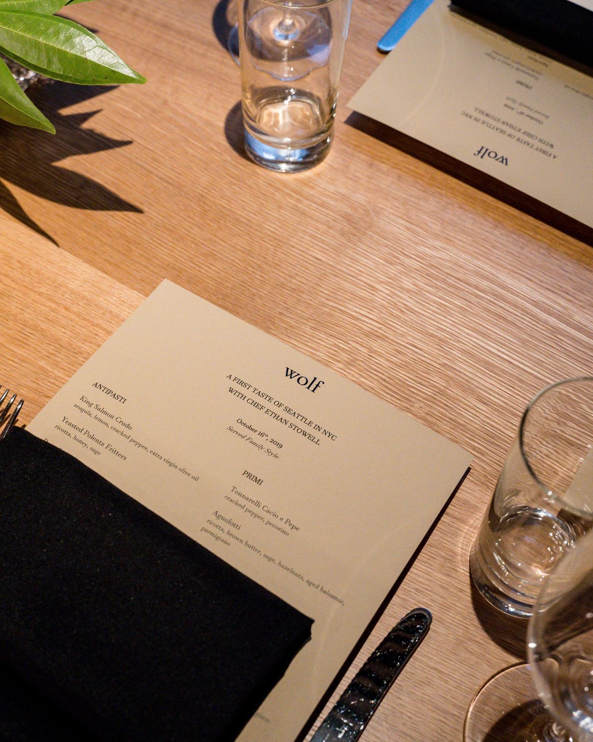A view of place settings and menus at a table in Nordstrom NYC's Wolf restaurant. 
