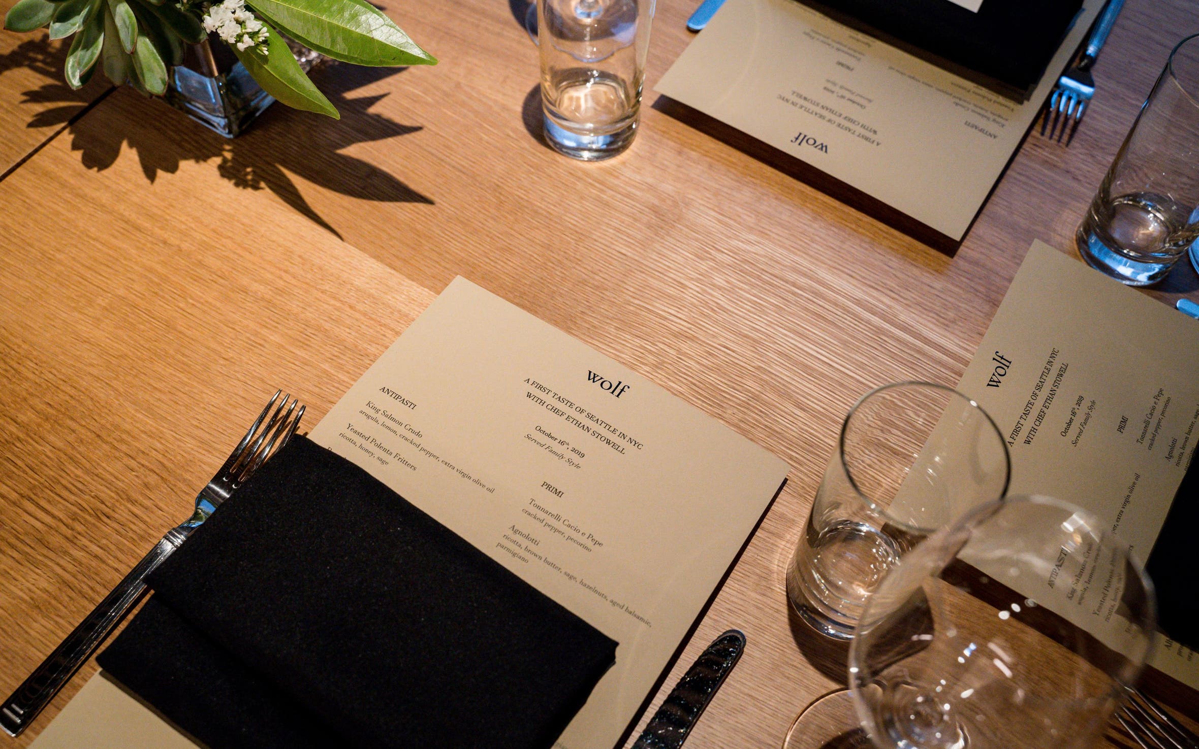 A view of place settings and menus at a table in Nordstrom NYC's Wolf restaurant. 