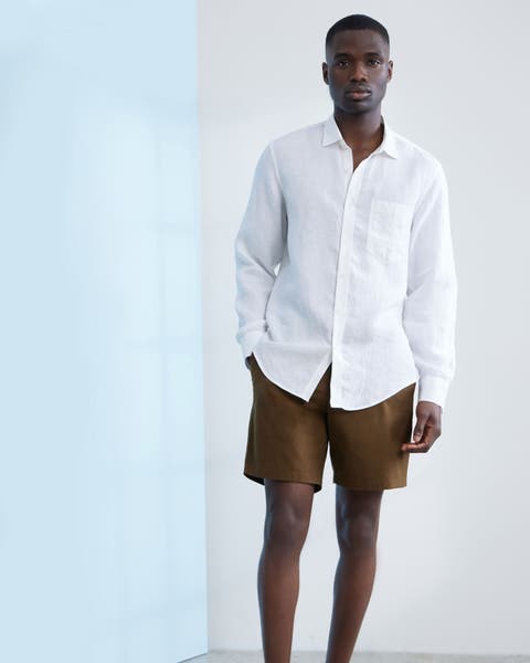 Man wearing white button up with brown shorts.
