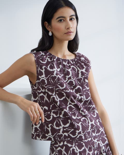 Woman wearing white and violet printed matching top and skirt set.