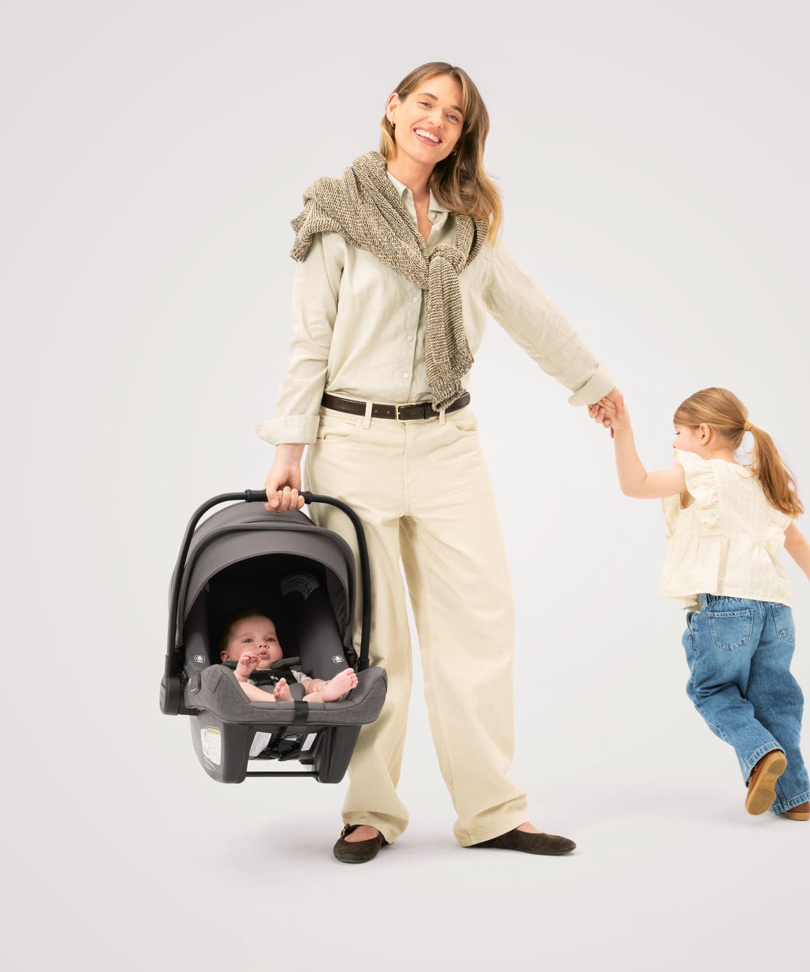 A woman, a little girl and a baby in a Nuna car seat from the Nordstrom-exclusive Pewter collection.
