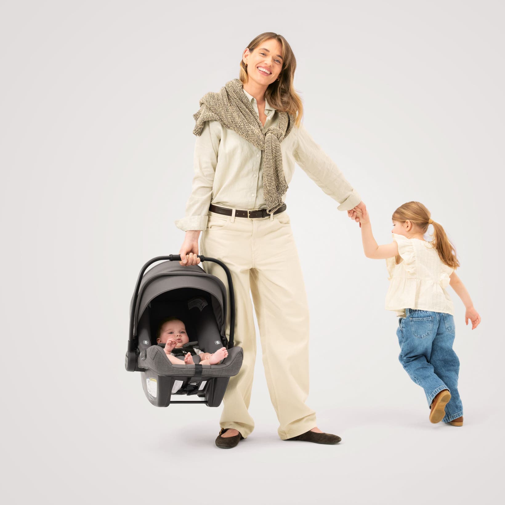 A woman, a little girl and a baby in a Nuna car seat from the Nordstrom-exclusive Pewter collection.