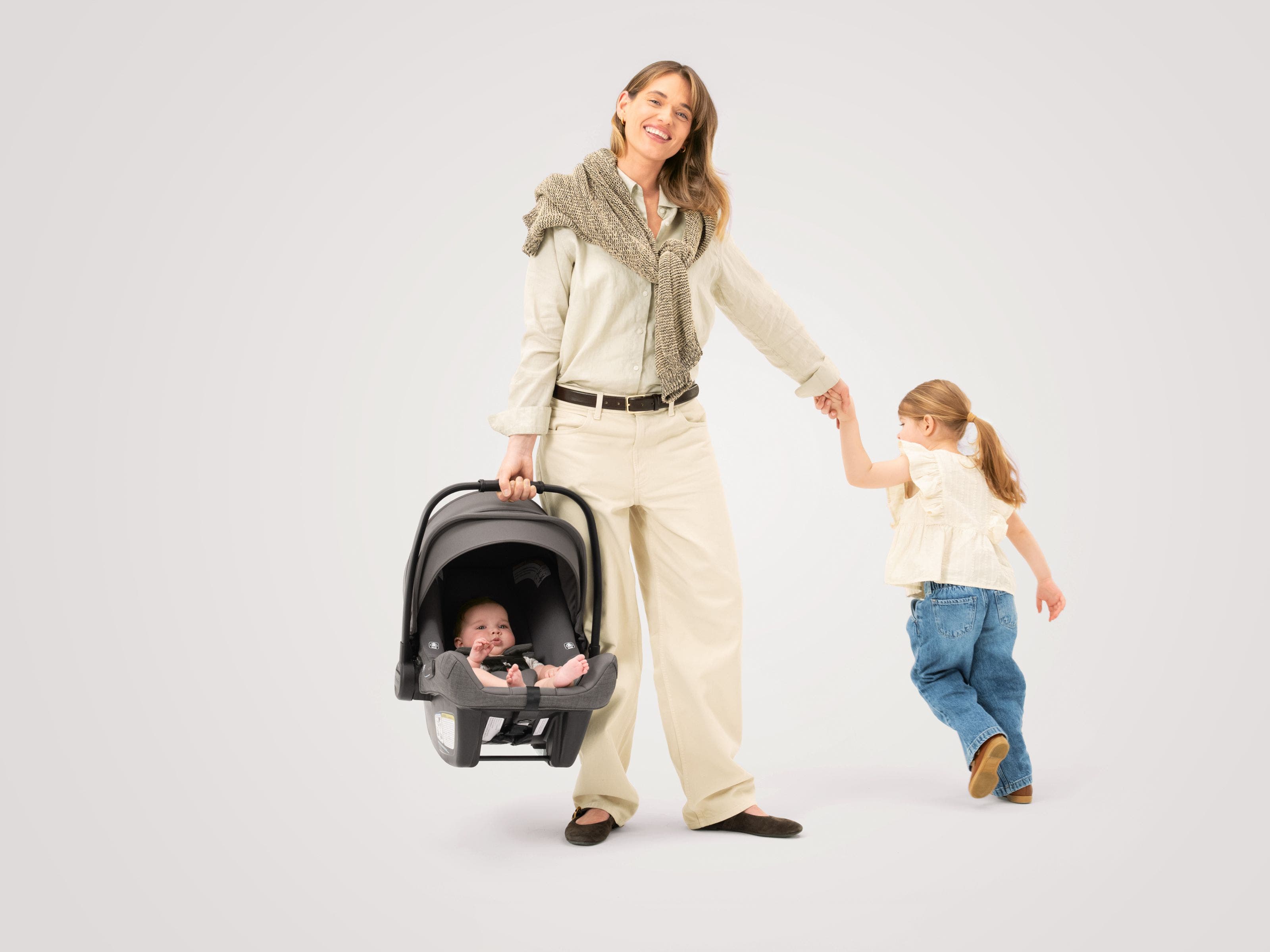A woman, a little girl and a baby in a Nuna car seat from the Nordstrom-exclusive Pewter collection.