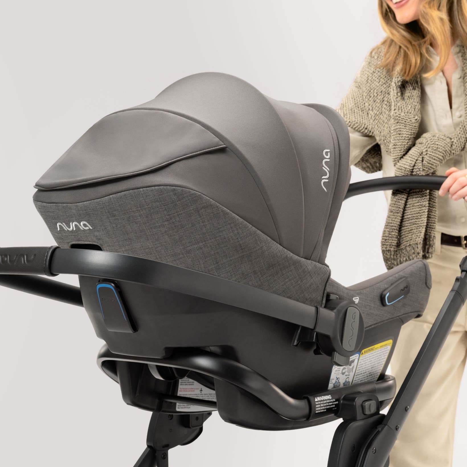 A woman pushing a baby in a Nuna travel system from the Nordstrom-exclusive Pewter collection.