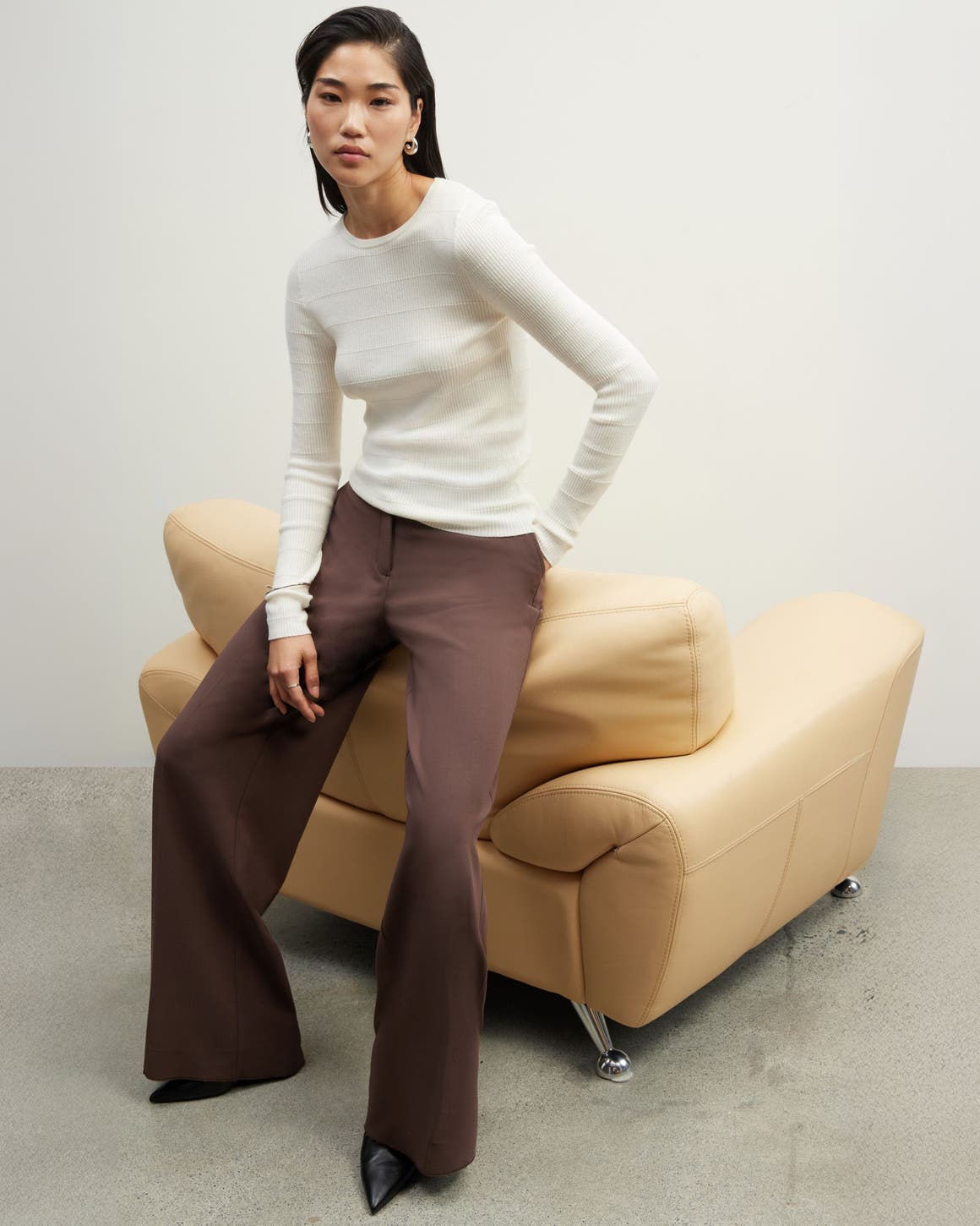 A woman in a cream sweater and brown pants from Nordstrom.