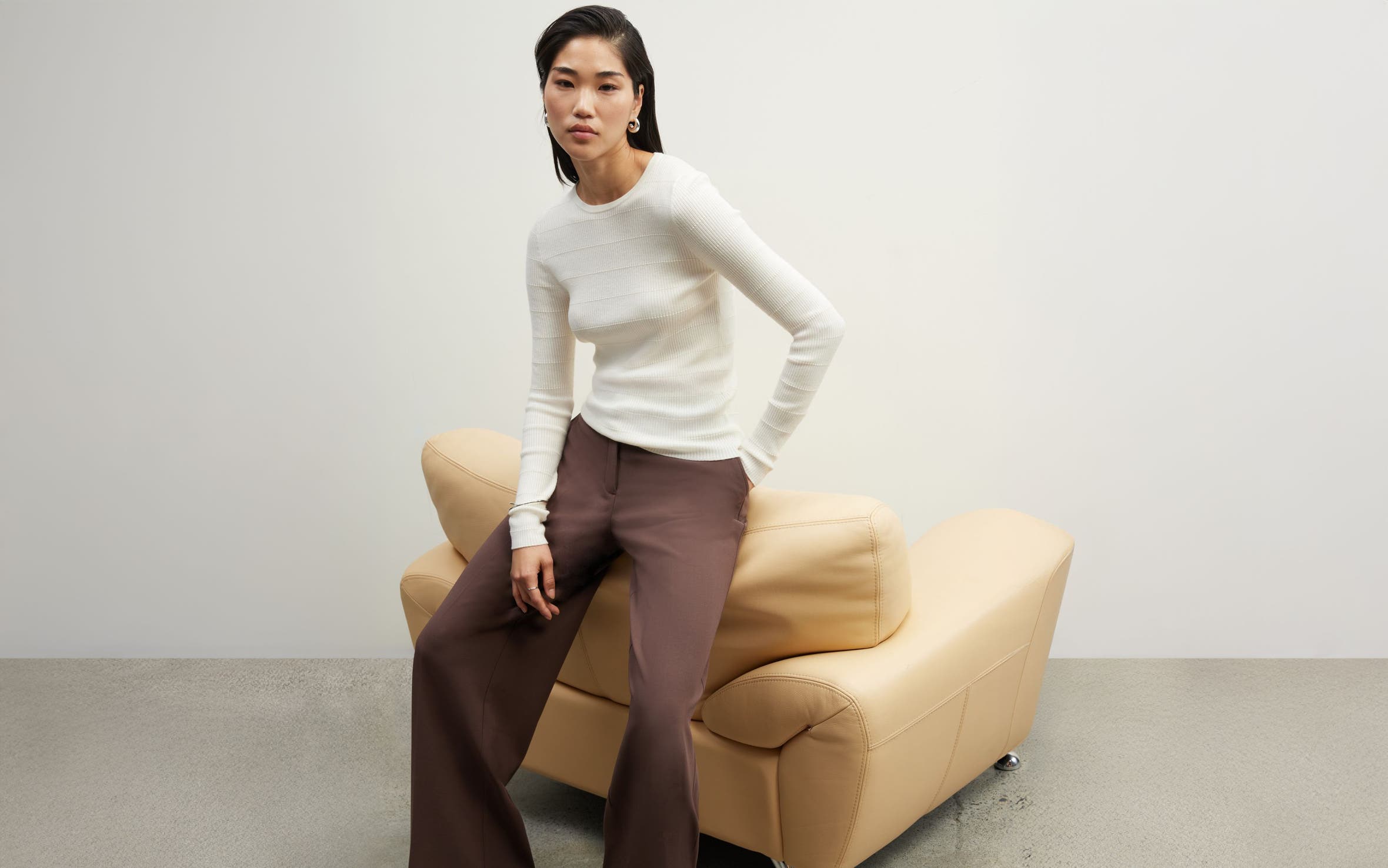 A woman in a cream sweater and brown pants from Nordstrom.