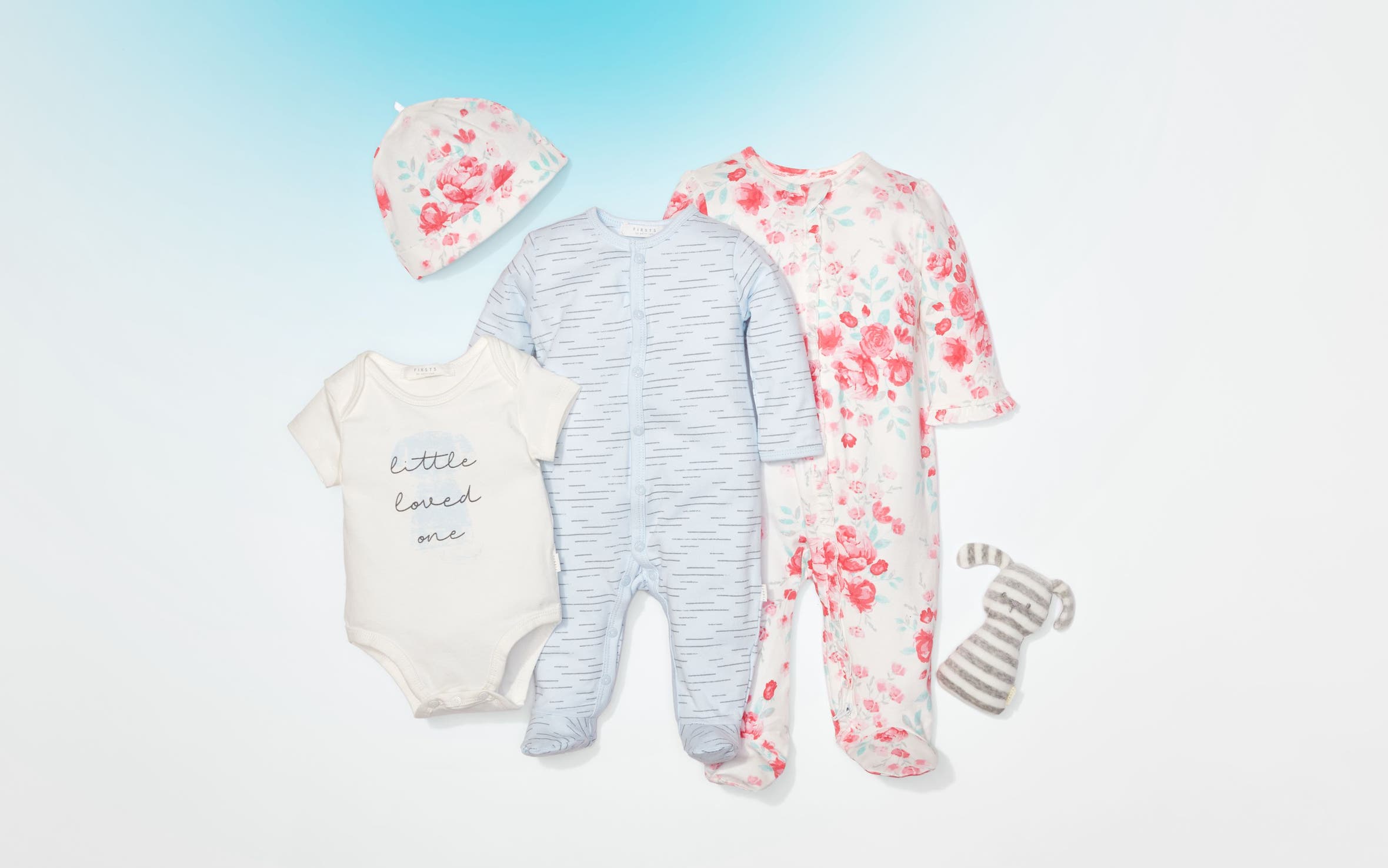 An array of baby clothing and a stuffed toy.