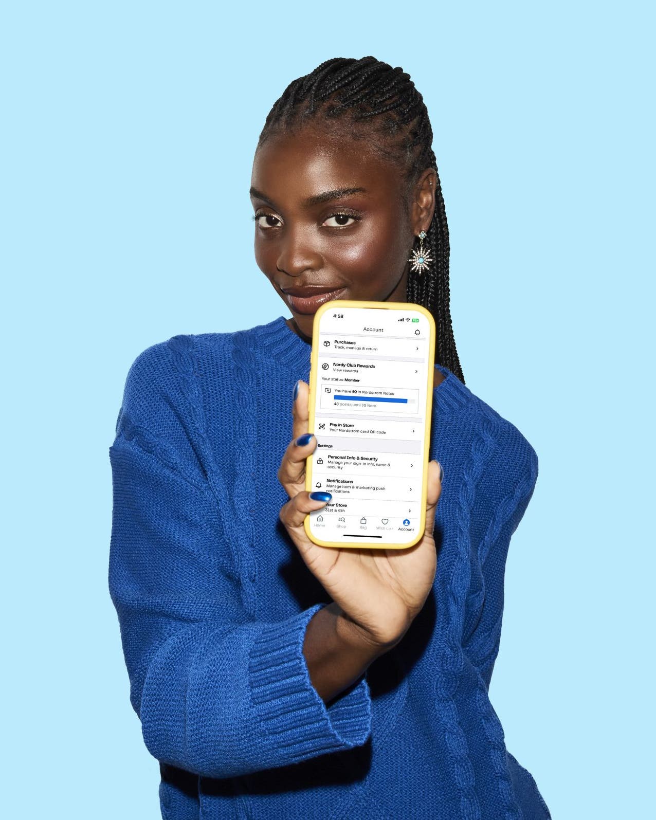 A woman holding up a cell phone showing the Nordstrom Rack app.