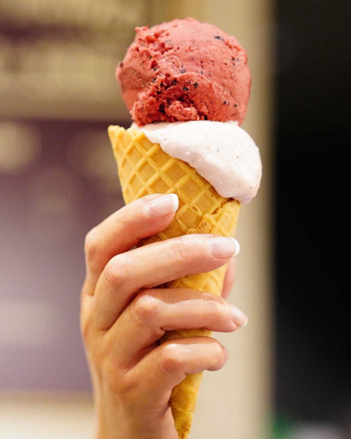 Hand holding a waffle cone filled with gelato.