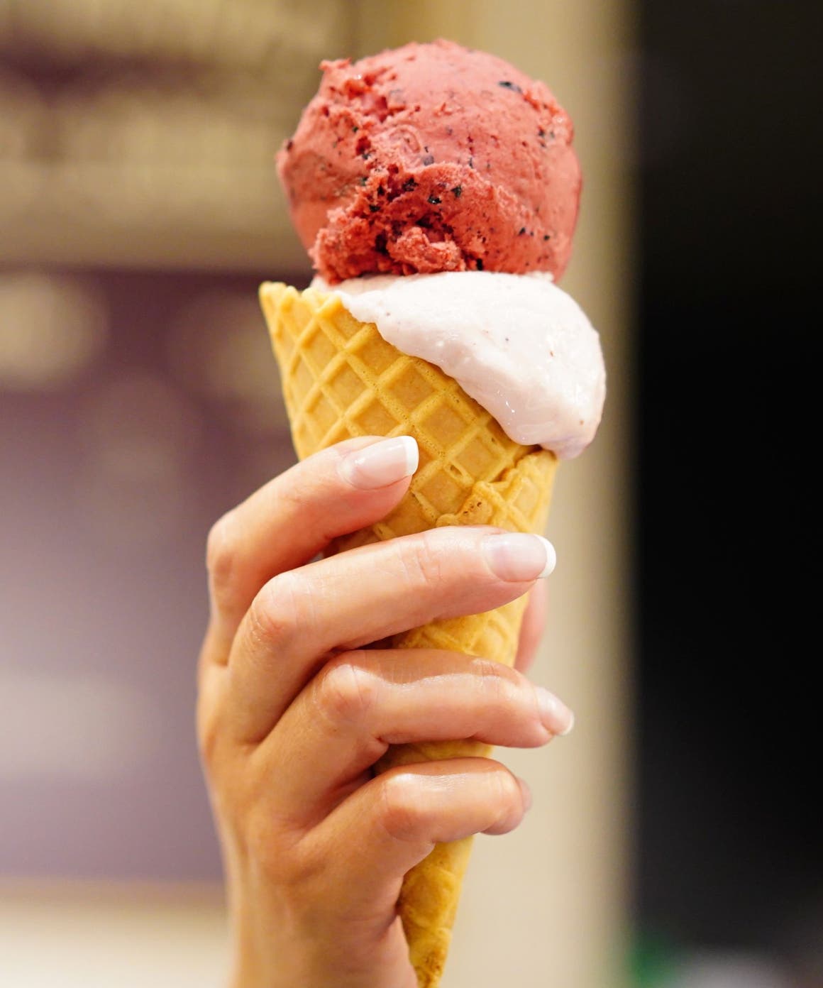 Hand holding a waffle cone filled with gelato.