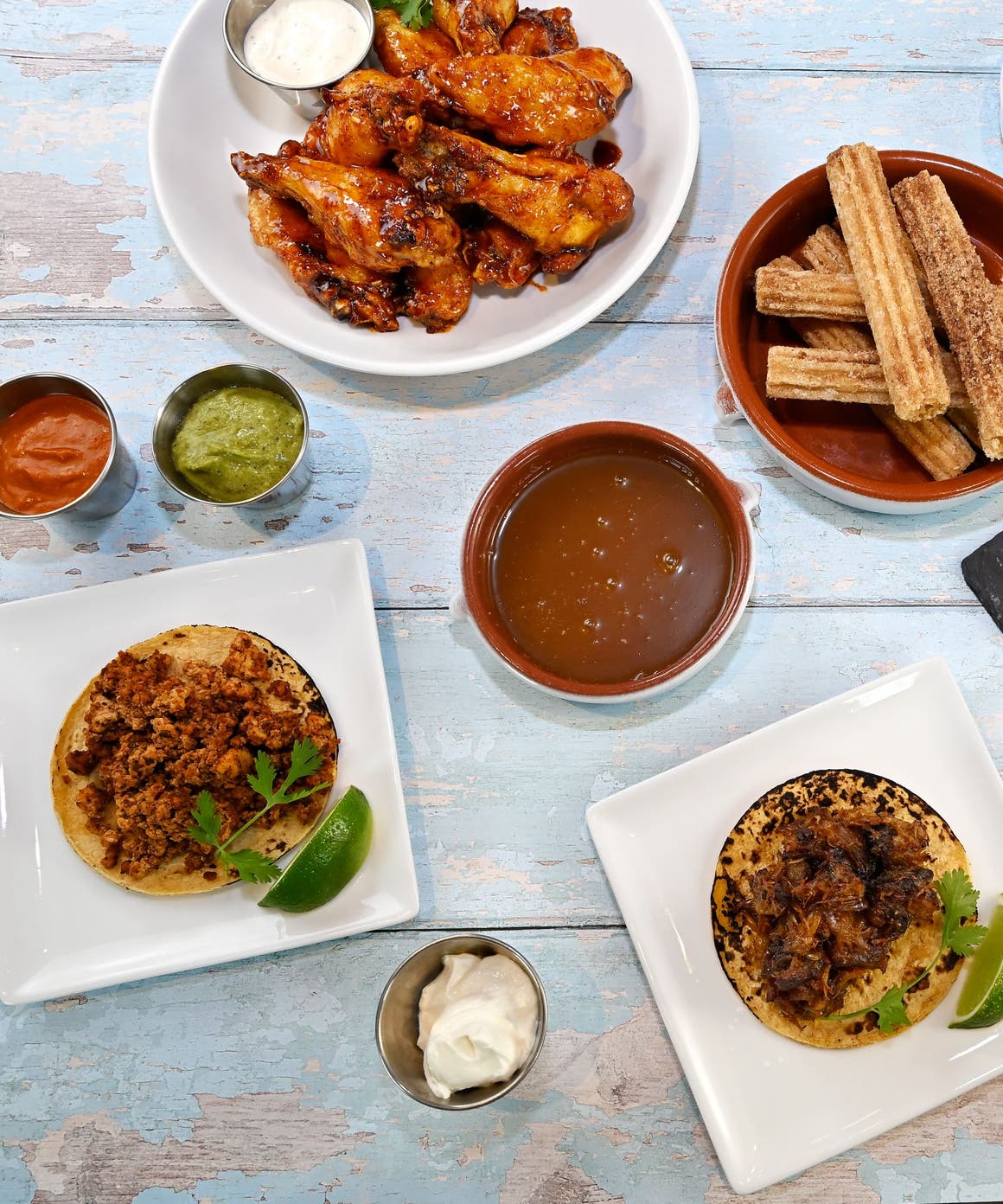 Picnic on 57th: a casual spread of picnic foods and tableware on a rustic blue picnic bench.