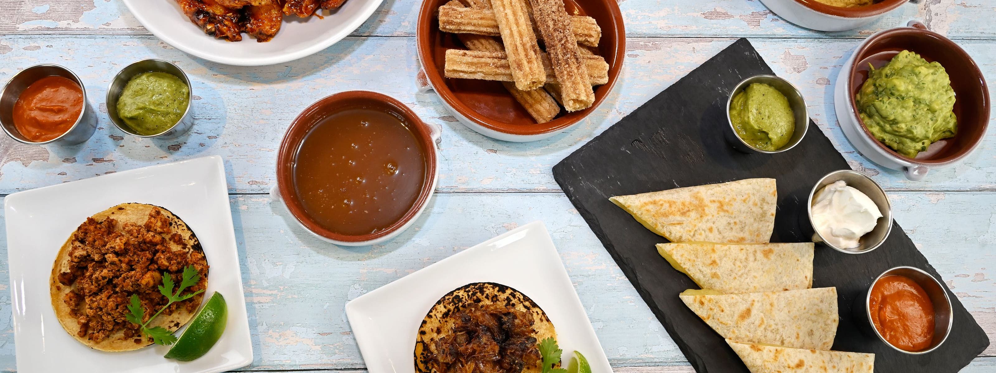 Picnic on 57th: a casual spread of picnic foods and tableware on a rustic blue picnic bench.