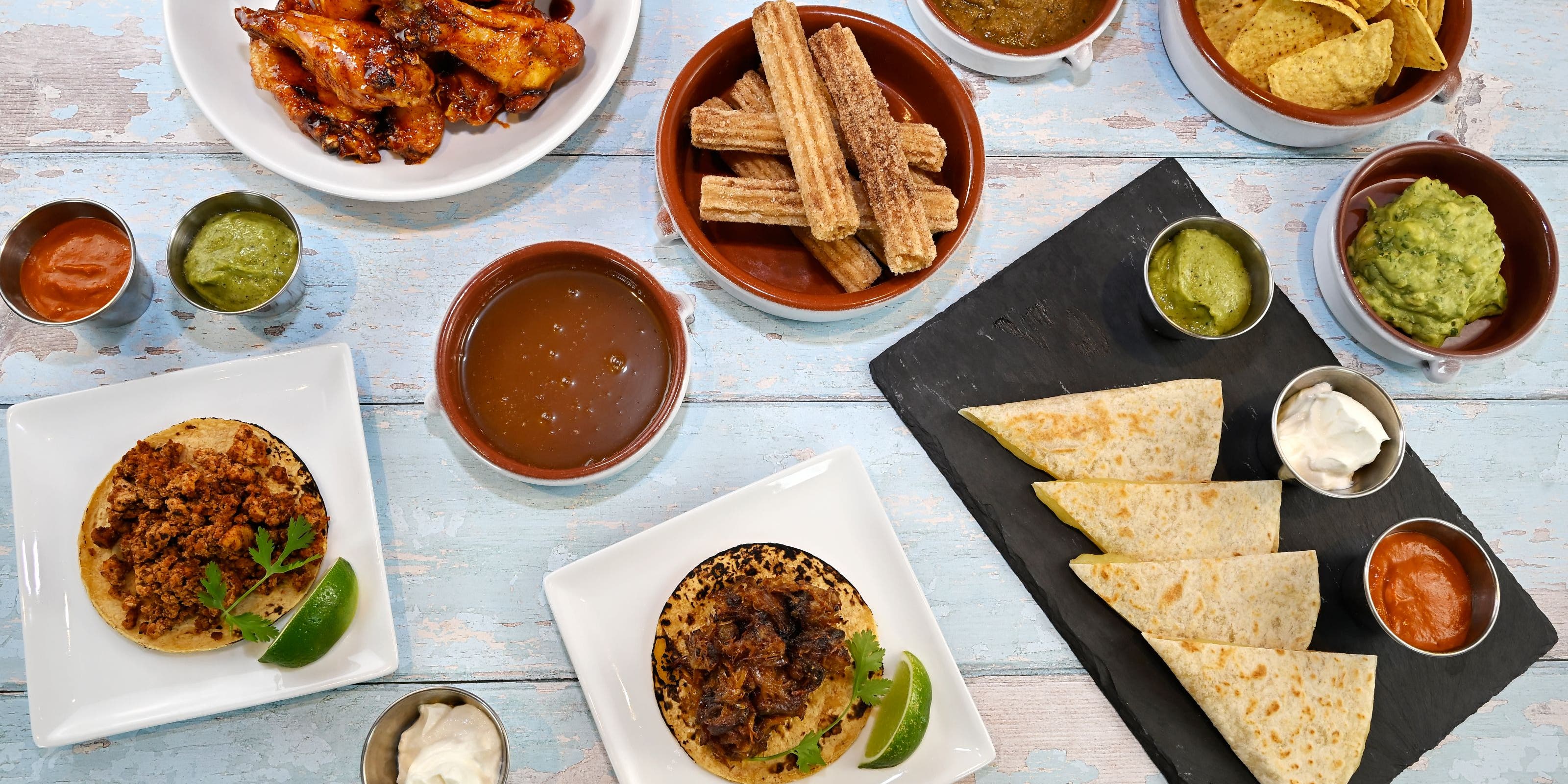 Picnic on 57th: a casual spread of picnic foods and tableware on a rustic blue picnic bench.