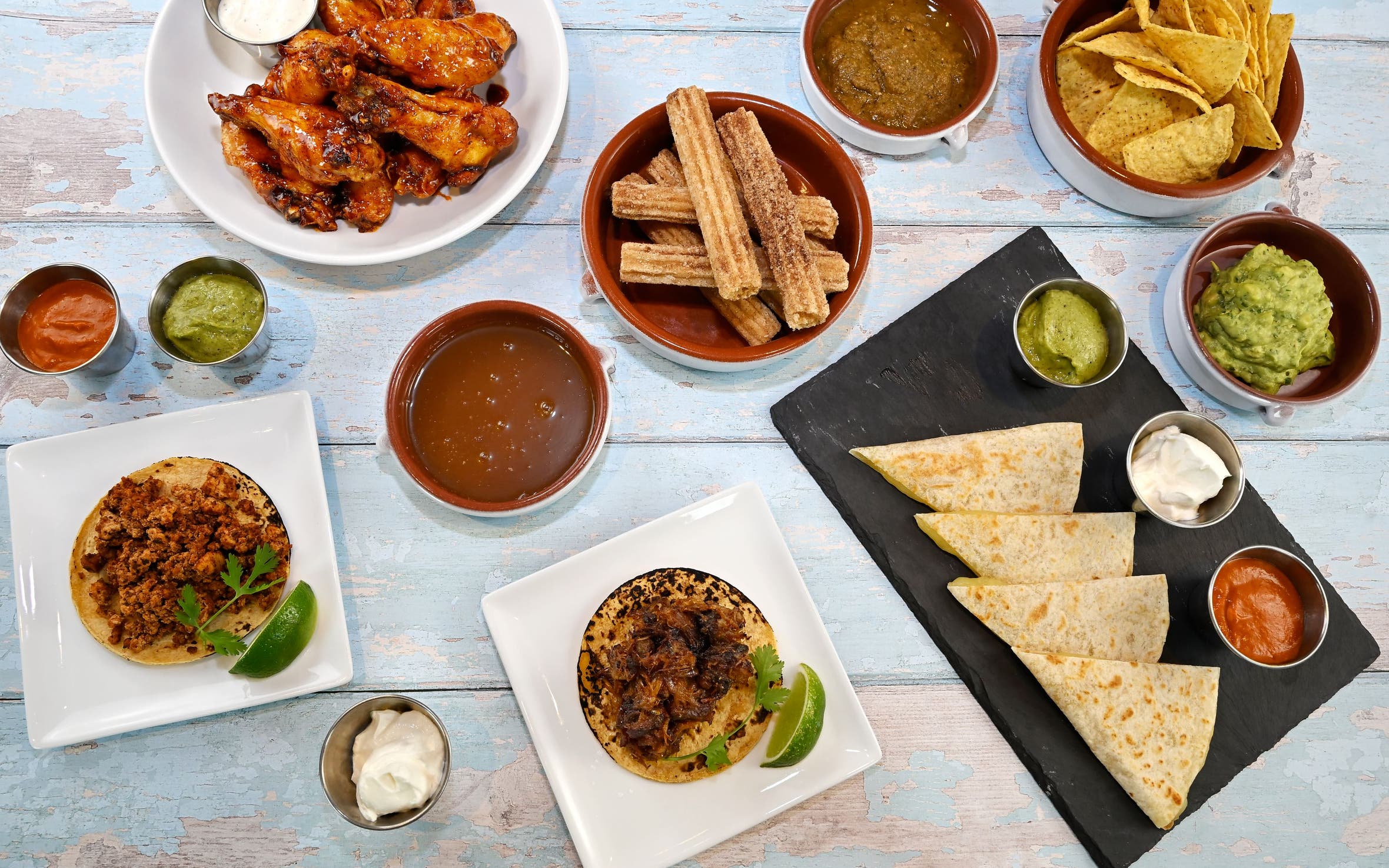 Picnic on 57th: a casual spread of picnic foods and tableware on a rustic blue picnic bench.