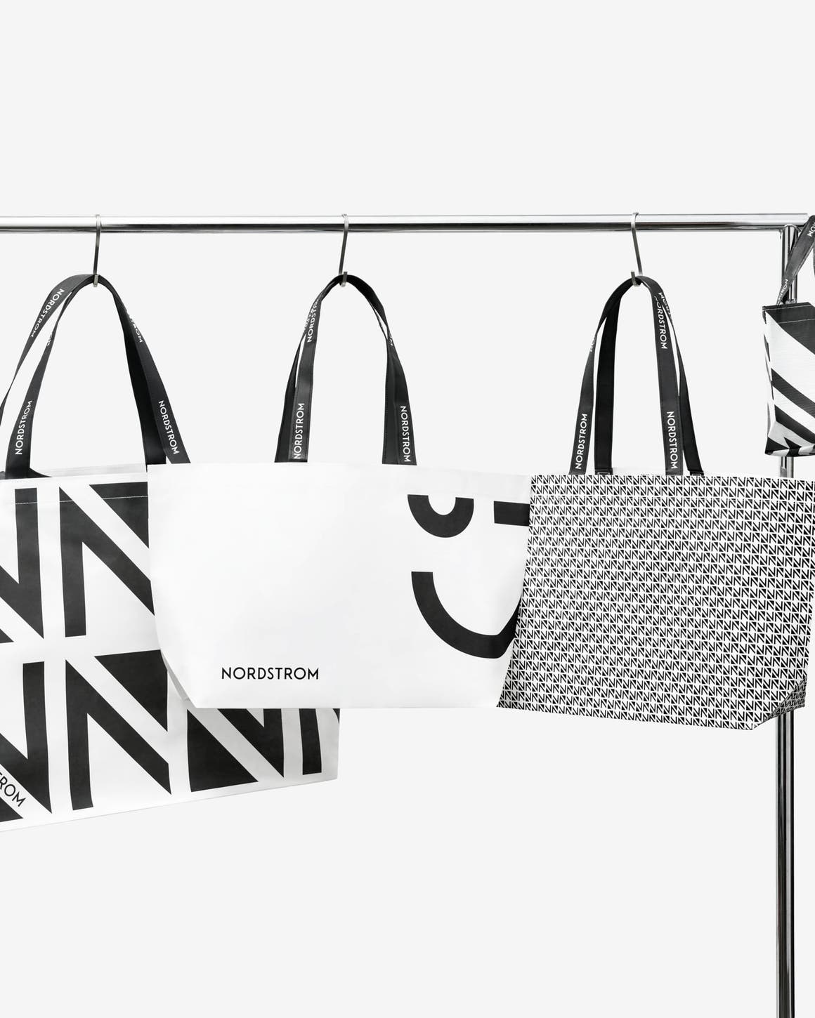 An assortment of Nordstrom shopping bags hanging on a rack.