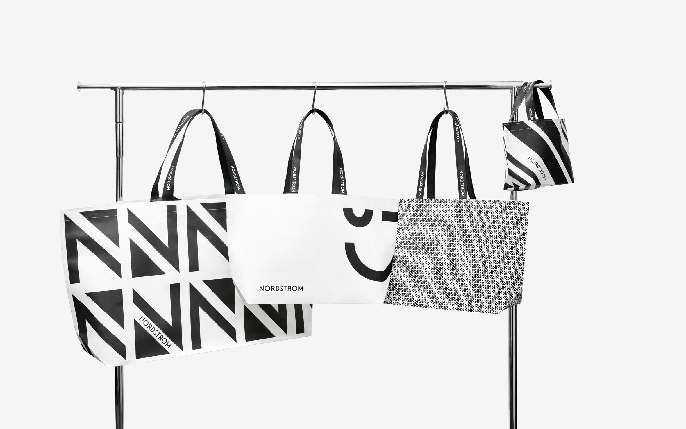 An assortment of Nordstrom shopping bags hanging on a rack.