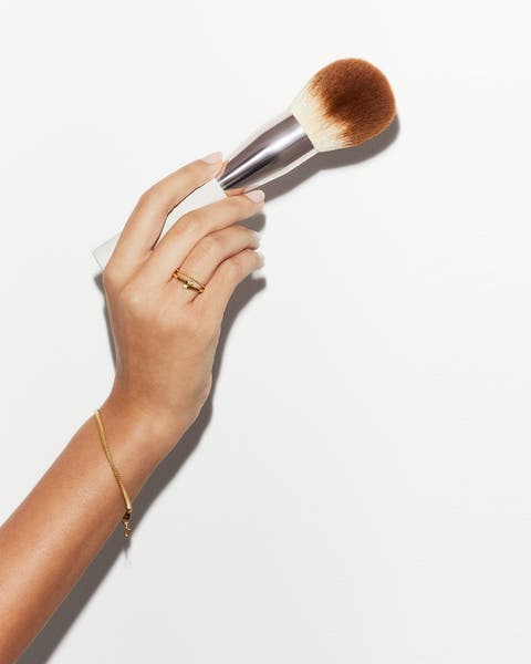 A woman holding a makeup brush