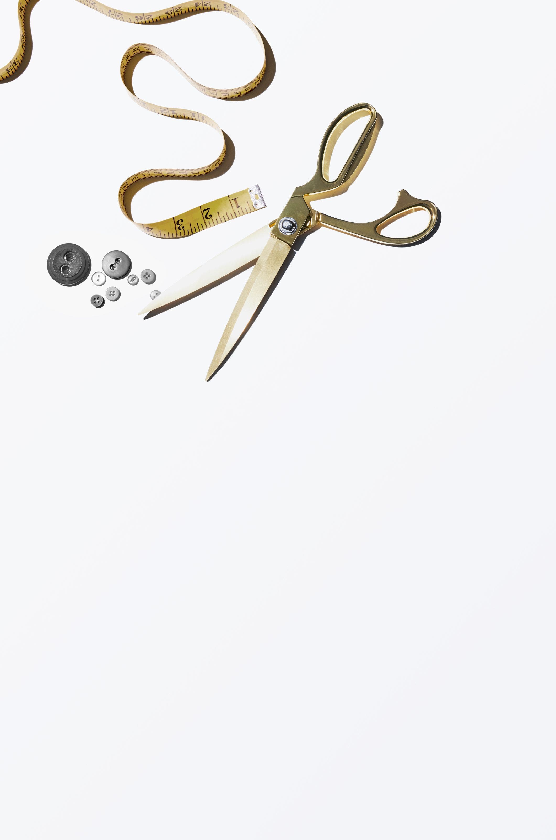 A measuring tape, buttons and dressmaker shears.