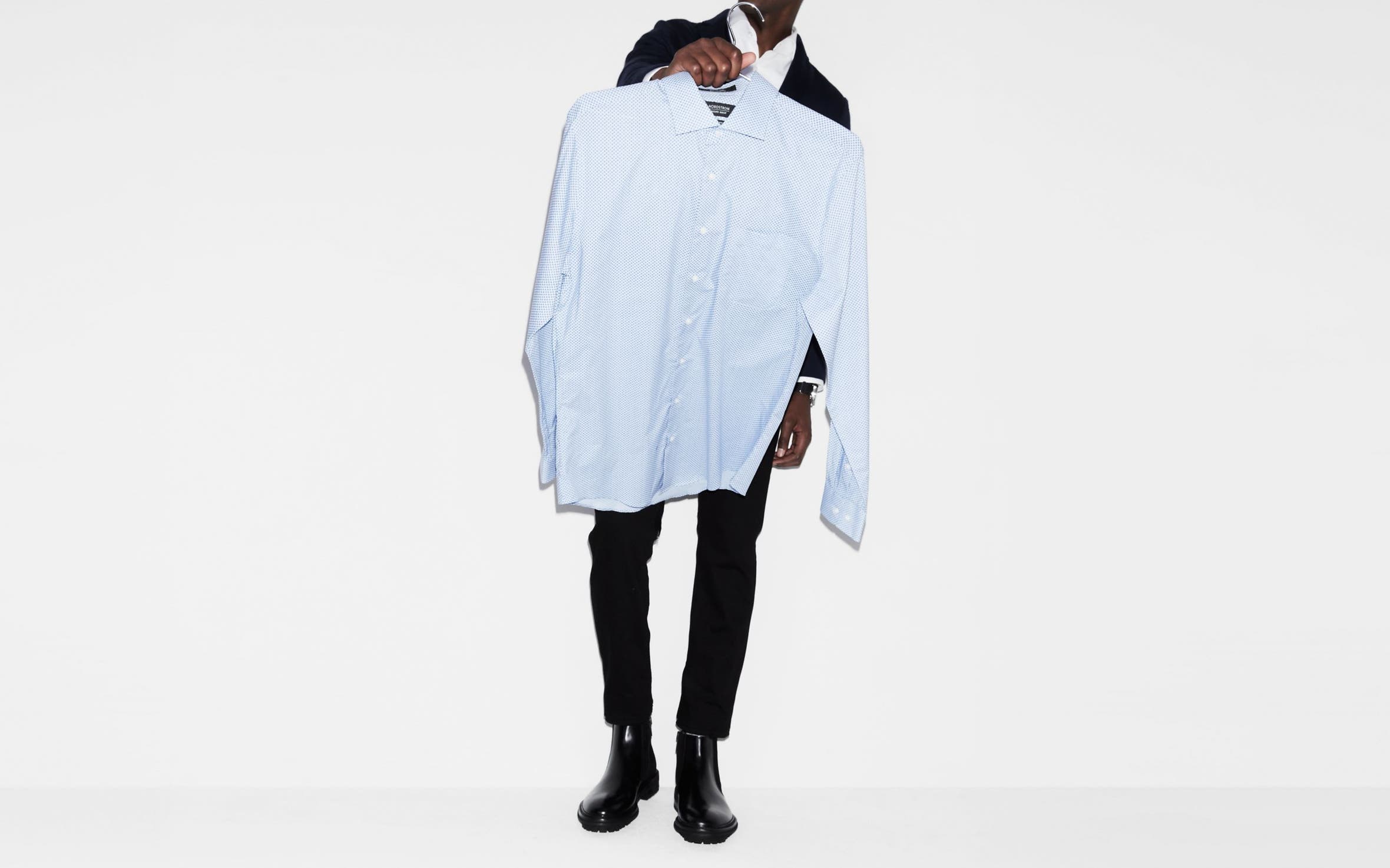 A man holding up a dress shirt.