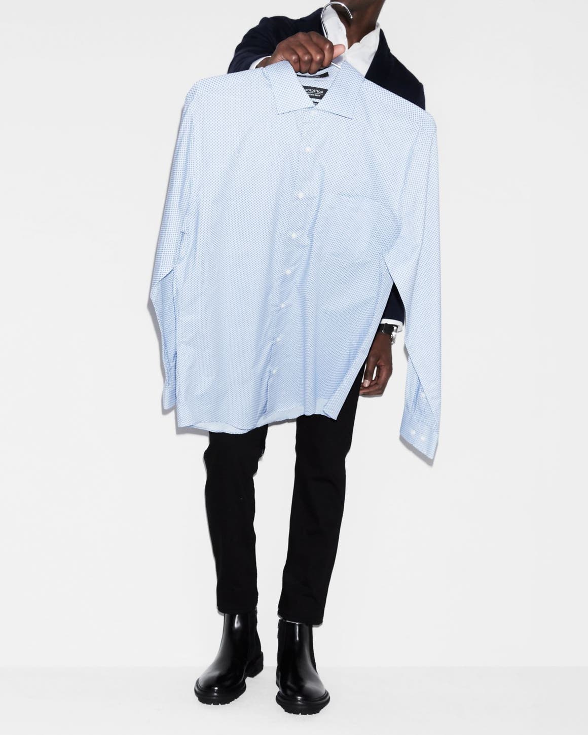 A man holding up a dress shirt.