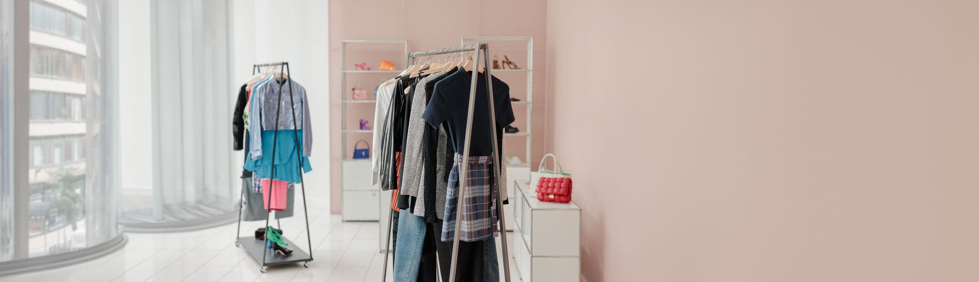 Racks of clothing and shelves holding shoes and handbags.