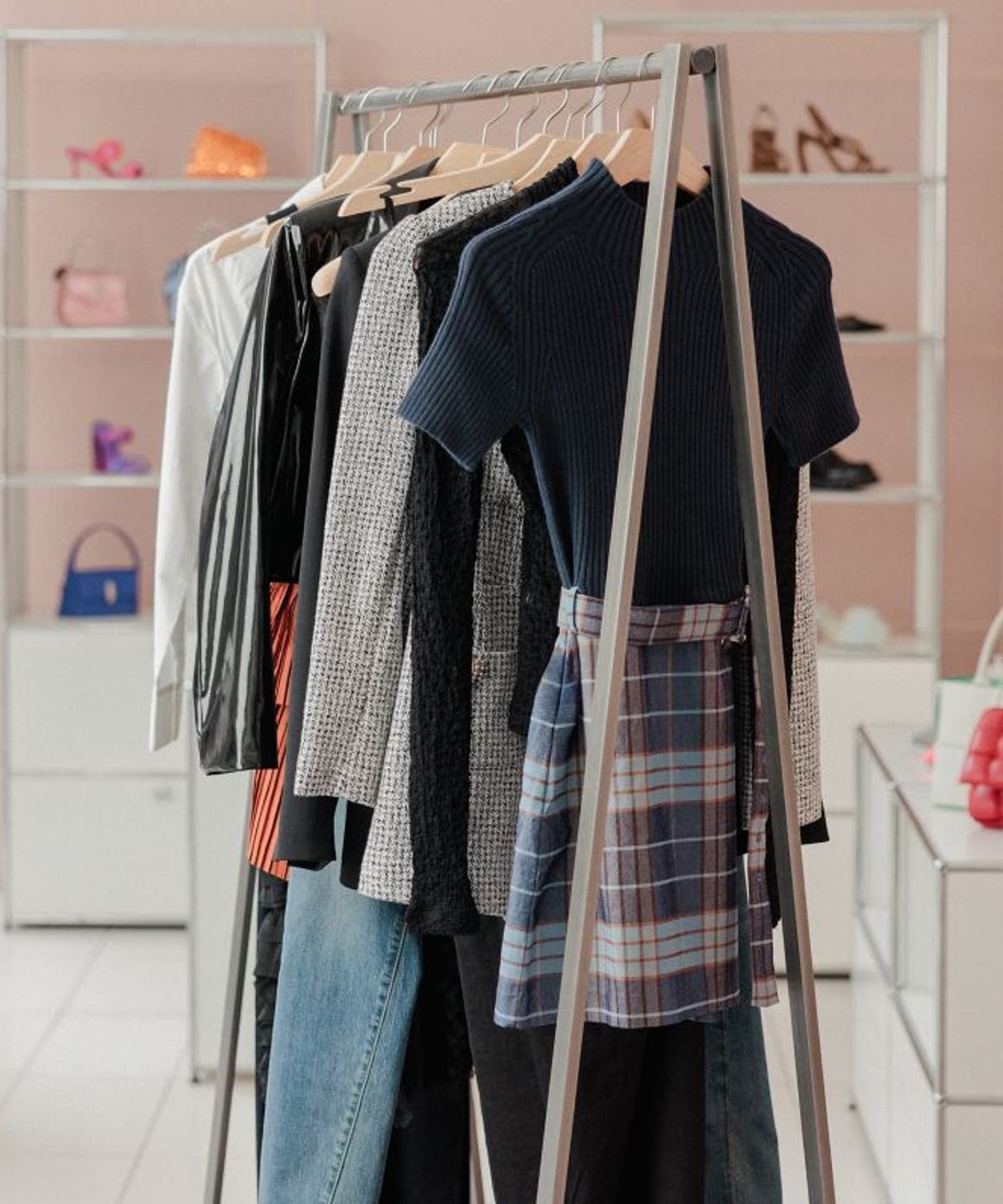 Racks of clothing and shelves holding shoes and handbags.