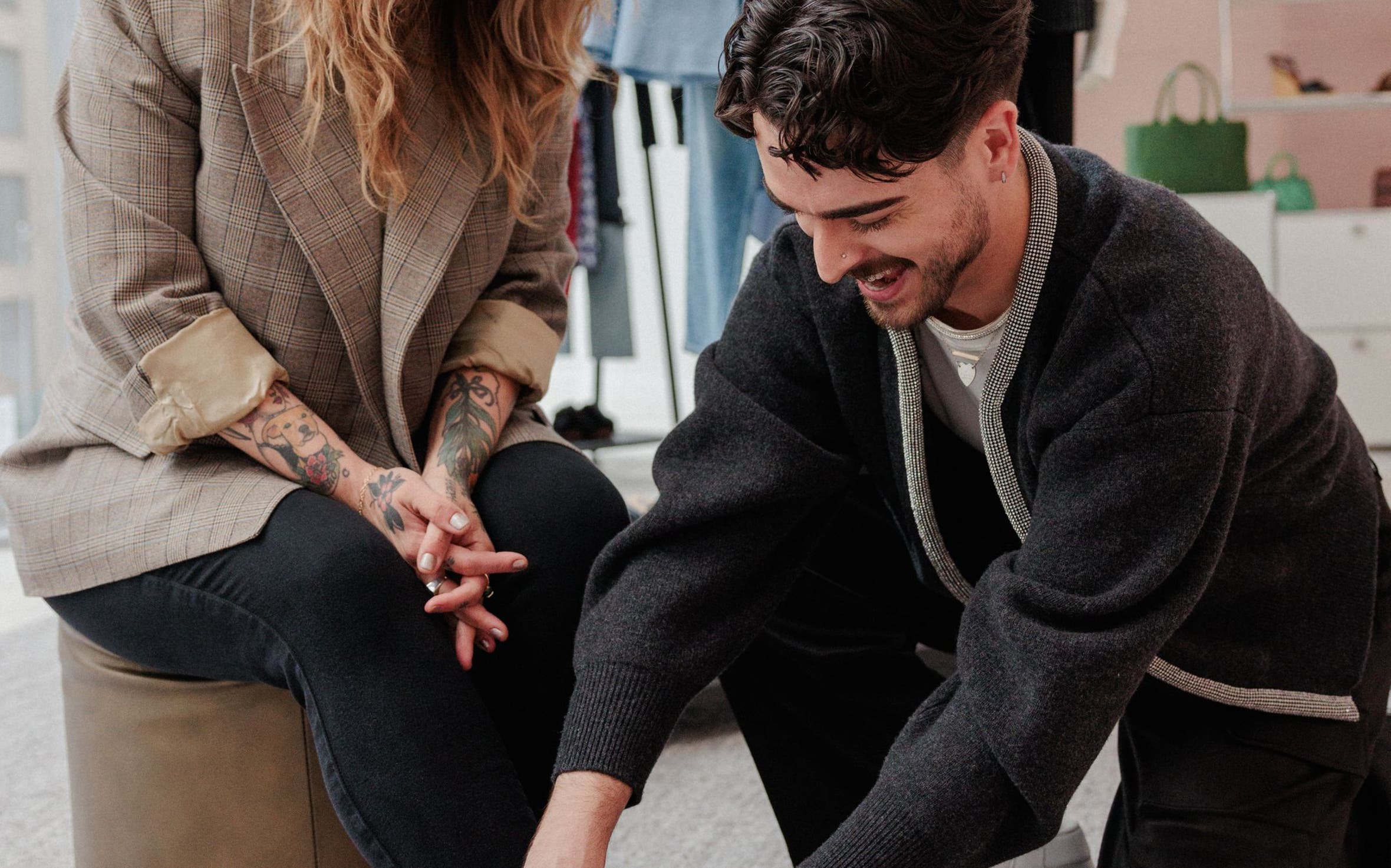 A girl getting her shoes put on by a stylist.
