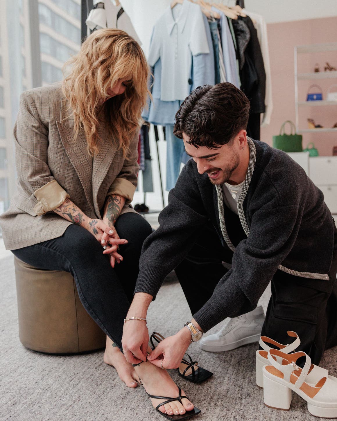 A girl getting her shoes put on by a stylist.