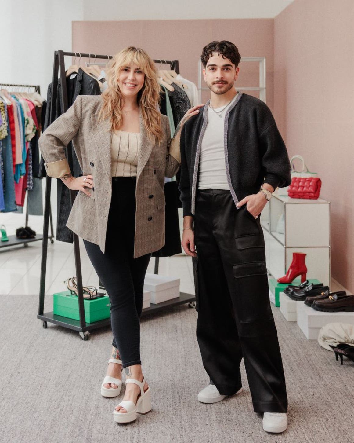 Two Nordstrom stylists in front of racks of clothing, shoes and accessories. 