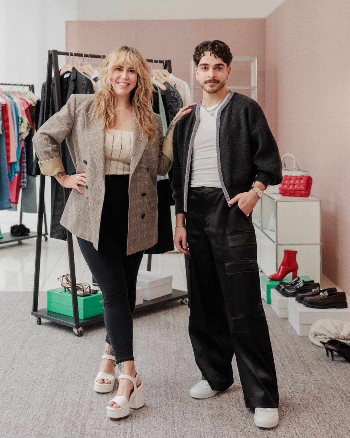 Two Nordstrom stylists in front of racks of clothing, shoes and accessories.