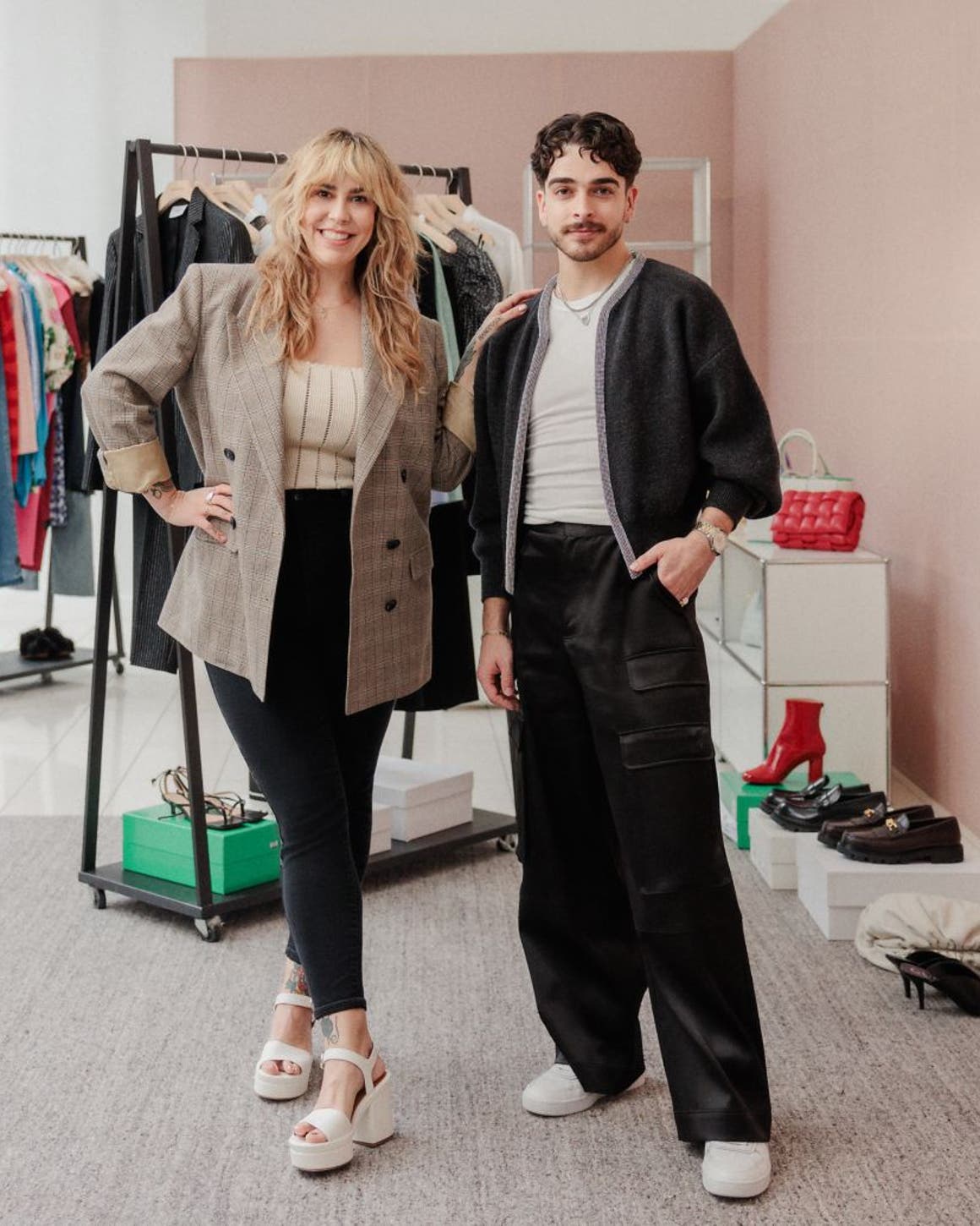 Two Nordstrom stylists in front of racks of clothes, shoes and accessories. 