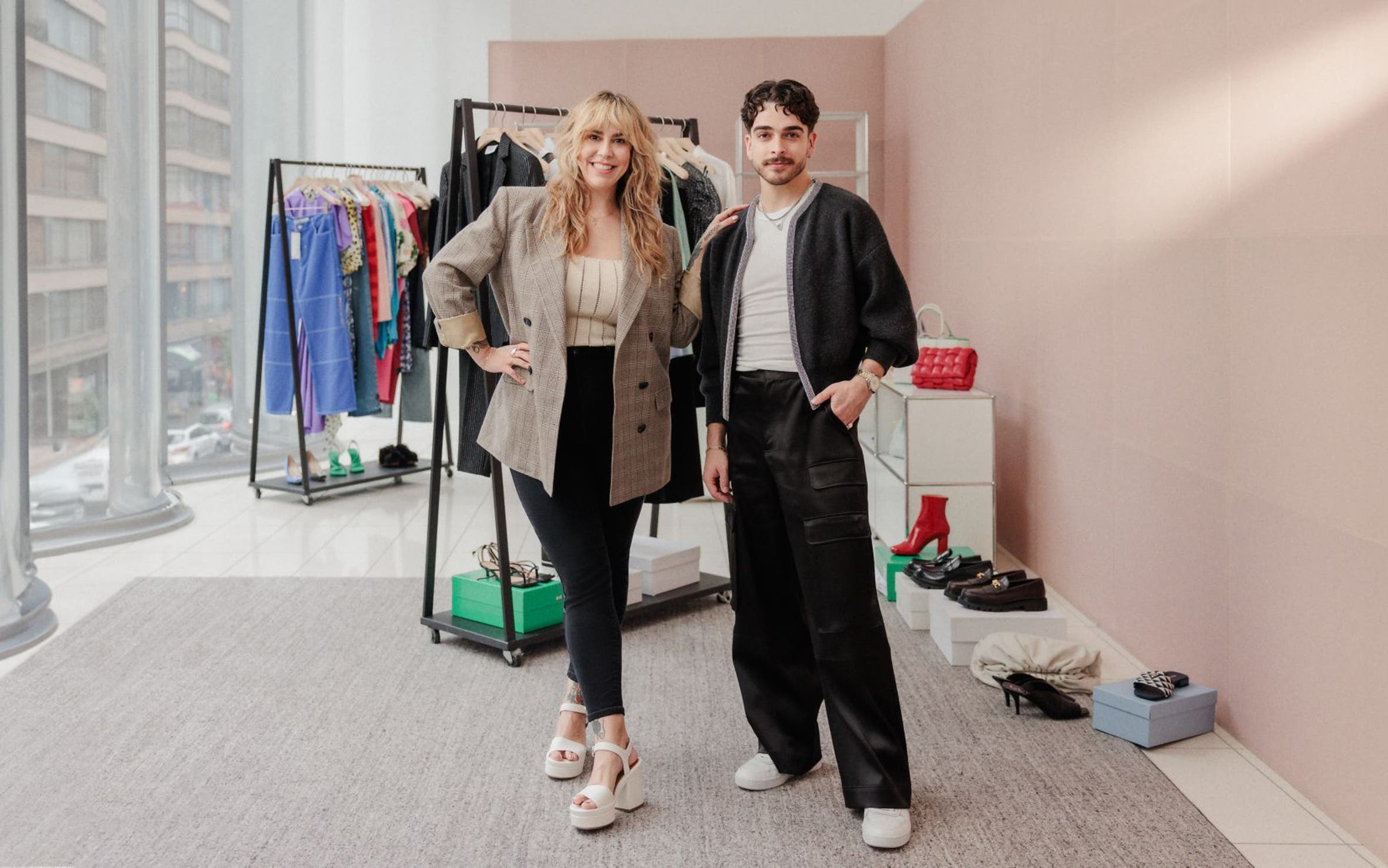 Two Nordstrom stylists in front of racks of clothing, shoes and accessories. 