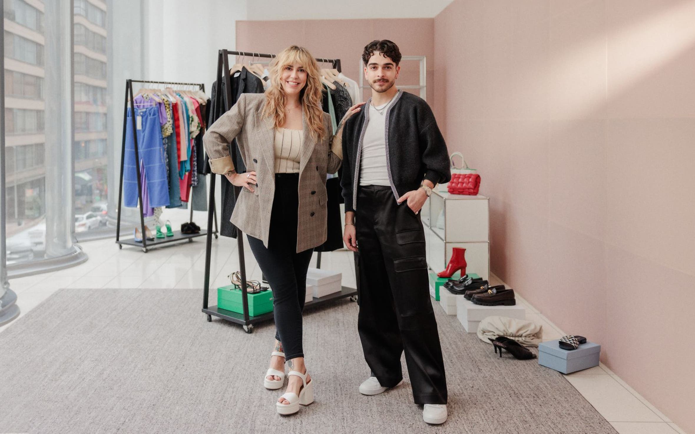 Two Nordstrom stylists in front of racks of clothes, shoes and accessories. 